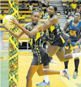  ?? FILE ?? Shanice Beckford holds the ball as Sunshine Girls captain Jhaniele Fowler (centre) looks on during a netball match between Jamaica and Barbados.