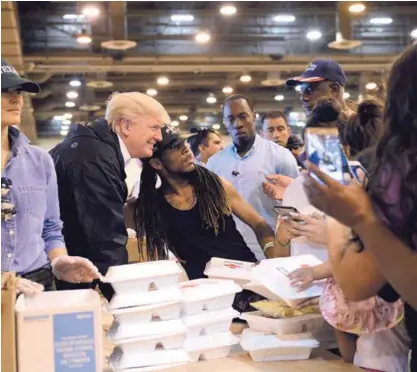  ?? AP ?? El presidente Donald Trump y su esposa, Melania Trump, repartiero­n comida y se tomaron selfies con personas afectadas por el huracán Harvey, este sábado, durante su visita al centro NRG en Houston.