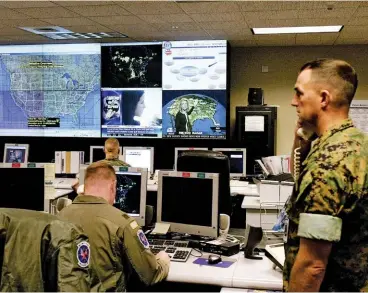  ??  ?? ON WATCH Military and civilian officers monitor screens at NORTHCOM’S Domestic Wing Center headquarte­rs in Colorado Springs, Colorado, in 2004.