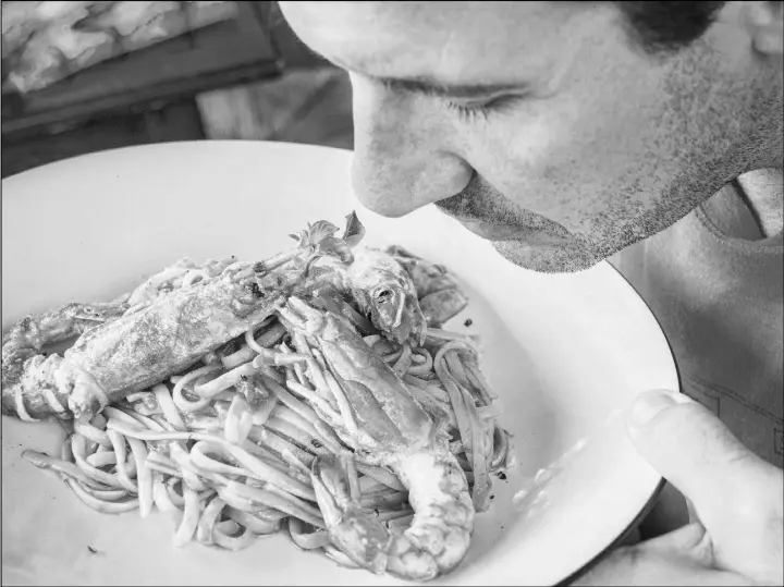  ?? FANFAN/FLICKR ?? A man sniffs a plate of pasta in Naples, Italy.