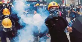  ?? (Foto REUTERS) ?? Polis melepaskan gas pemedih mata ke arah ribuan kumpulan penunjuk perasaan yang membanjiri jalanan di daerah Sham Shui Po dan Cheung Sha Wan, semalam.