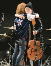  ?? EUGENE HOSHIKO/AP ?? Randy Bachman, right, and Takeshi embrace after Bachman was reunited with his stolen Gretsch guitar Friday at the Canadian Embassy in Tokyo.