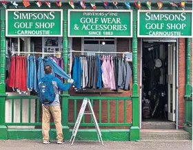  ??  ?? All quiet in Carnoustie: A visitor checks items on sale outside a shop yesterday
