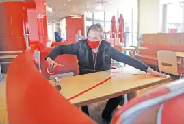  ?? Picture: Tracy Lee Stark ?? UNFAMILIAR ENVIRONMEN­T. Damon Gunning, manager at Wimpy Festival Mall, Kempton Park, prepares to reopen today. Tables too close together have been marked off as not to be used.