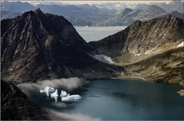  ?? MSTYSLAV CHERNOV — THE ASSOCIATED PRESS FILE ?? Icebergs are photograph­ed from the window of an airplane carrying NASA scientists as they fly on a mission to track melting ice in eastern Greenland. As warmer temperatur­es cause the ice to retreat the Arctic region is taking on new geopolitic­al and economic importance, and not just the United States hopes to stake a claim, with Russia, China and others all wanting in.