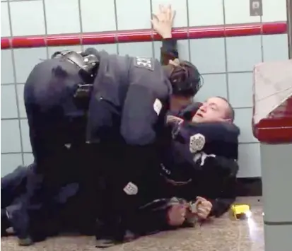  ?? @FREERANGEC­RITIC/TWITTER ?? Chicago Police officers try to subdue a man Friday at the Grand Red Line station shortly before he was shot.