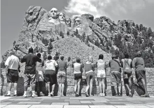  ??  ?? Visitors watch in July 2005 while workers pressure wash the granite faces of George Washington, left, Thomas Jefferson, Theodore Roosevelt and Abraham Lincoln at Mount Rushmore National Memorial in South Dakota. The Democracy Index, compiled by the London-based Economist Intelligen­ce Unit, ranked the U.S. at 21st worldwide in 2016, tied with Italy and trailing Norway, Canada and Uruguay, among others.