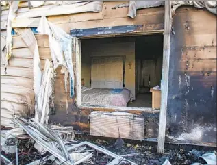  ??  ?? A CROSS hangs in an unscathed bedroom of a senior-living home on Saturday. Aided by light rains, emergency crews on Sunday fully contained the Camp fire, California’s worst on record.