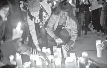  ?? AGENCE FRANCE PRESSE ?? Mourners light candles during a vigil at the corner of Sahara Avenue and Las Vegas Boulevard for the victims of Sunday night's mass shooting in Las Vegas, Nevada.