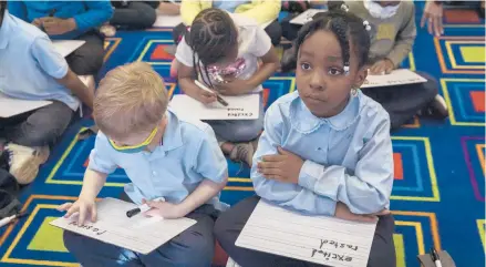  ?? THALIA JUAREZ/THE NEW YORK TIMES ?? First-graders work on spelling and writing April 14 at an elementary school in the Brooklyn borough of New York City.