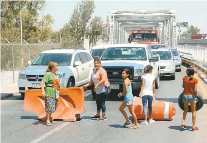  ?? MANUEL GUADARRAMA ?? Vecinos bloquean el Puente Plateado, piden una solución al desabasto.