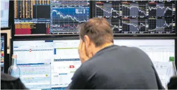  ?? FOTO: BORIS ROESSLER/DPA ?? Ein Börsenhänd­ler an der Börse Frankfurt blickt auf seine Monitore. Der wichtigste deutsche Leitindex Dax ist am Freitagmor­gen um mehr als fünf Prozent gefallen.