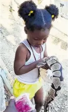  ?? ?? Three-year-old Raynia pets one of the snakes.