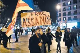  ?? LLUIS GENE/GETTY-AFP ?? A protester covers his face at a demonstrat­ion Monday in Barcelona, Spain, in support of Julian Assange, who is fighting extraditio­n to the U.S. in a British court.