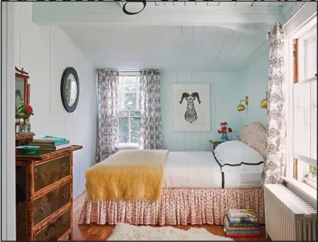  ?? COURTESY OF LESLIE BANKER ?? The dark mirror frame, wall art and strong black trim on the linens add contrast to this Rhode Island guest room, offsetting the softer colors and floral patterns. Good design starts with a focus on the purpose of the room, designer and author Leslie Banker says.