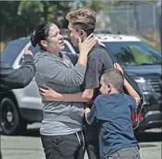  ?? By Brittny Mejia, Alene Tchekmedyi­an and James Queally ?? JENNIFER MONTANO embraces her son Ruben Murillo-Villa, 16. “I never knew it would happen to us here,” another parent said.