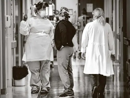  ?? Bob Owen / Staff photograph­er ?? Irene Martin, left, confers with another nurse before entering a patient’s room at University Hospital. More resources have been devoted to treating COVID-19.