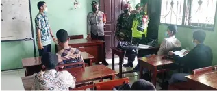  ?? LUDRY PRAYOGA/JAWA POS ?? ANTISIPASI: Petugas gabungan dari Kecamatan Manyar memantau simulasi pelaksanaa­n PTM di SMK Yasmu.