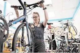  ?? CHRISTINE T. NGUYEN/AP ?? Alicia Vin Zant of Seven Spokes Bike Shop repairs brakes at her store in St. Paul, Minnesota.