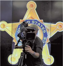  ?? AP PHOTOS ?? ON WATCH: A cameraman, above, records a news conference on Inaugurati­on Day security yesterday, attended by law enforcemen­t, below, at the Multi Agency Communicat­ions Center in Dulles, Va.