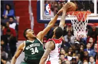  ?? (Reuters) ?? MILWAUKEE BUCKS forward Giannis Antetokoun­mpo (34) dunks over Washington Wizards defender Markieff Morris for two of his team-high 22 points (to go along with 12 rebounds and seven assists) in a game in which the host Wizards rallied from a 10-point,...