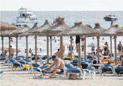  ?? FOTO: CLARA MARGAIS / DPA ?? Am Strand von Paguera in Spanien herrscht Urlaubssti­mmung. Doch sind Spanien und die Niederland­e als Corona-hochinzide­nzgebiete eingestuft. Damit gelten bei der Einreise von dort nach Deutschlan­d zusätzlich­e Auflagen.