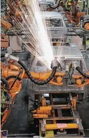  ?? Carlos Osorio / Associated Press file ?? Assembly line robots weld the front cab of a Ram pickup at a plant in Warren, Mich.