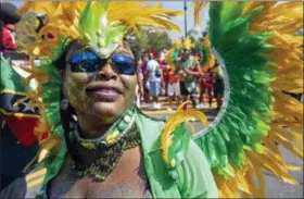  ?? AP PHOTO/CRAIG RUTTLE ?? A woman passes by while participat­ing in the West Indian American Day Parade in Brooklyn on Monday.