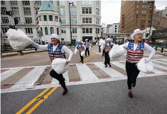  ?? (AP Photo/ Kenny Yoo) ?? Colleen Minisce, left, and Janet Polley, right, and other members of the Milwaukee Dancing Grannies perform by at a Veterans’ Day parade on Nov. 5 in Milwaukee. The Grannies have recently added several new members, including Minisce and Polley, as they’ve rebuilt after tragedy hit last year at a Christmas parade in Waukesha, Wis. Three Dancing Grannies and one group member’s husband were among those killed when the driver of an SUV struck them on the parade route. Dozens more, including some Grannies, were injured.