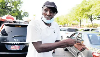  ?? KENYON HEMANS/PHOTOGRAPH­ER ?? Taxi operator Fredrick Fox, who plies the Half-Way Tree to Papine route, speaks on Monday about the challenges he believes would arise from a fare increase. At least one transport lobby has called for a 100 per cent rise in fares.