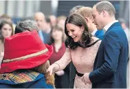  ??  ?? Beaming Kate is waltzed by the bear. Prince William, left, also met the famous character during the event to promote children’s charities