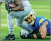  ?? TERRY PIERSON — SCNG ?? Los Angeles Chargers' Joey Bosa pulls down Detroit Lions running back Jahmyr Gibbs during a game at SoFi Stadium in Inglewood on Nov. 12.