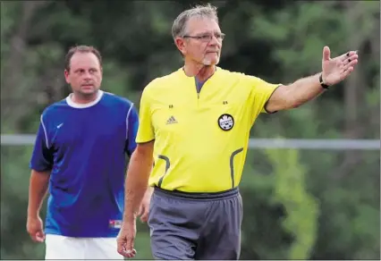  ?? NICK BRANCACCIO/THE Windsor Star ?? Veteran referee Frank Pavicic, right, officiates a Windsor and District Soccer League game at McHugh Park.