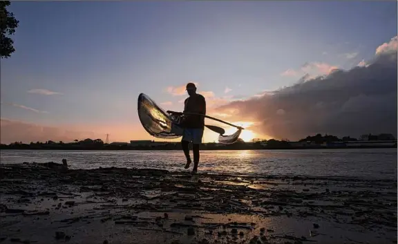  ?? Photos by Brett Phibbs / Associated Press ?? Tahi Nepia, an outrigger canoe paddler, is also a caretaker at a local Maori immersion school in New Zealand.
