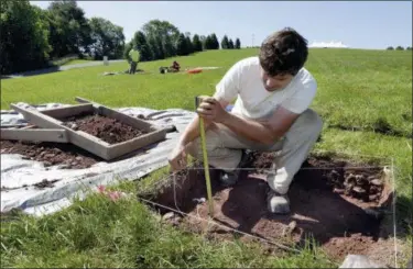  ?? RICHARD DREW — ASSOCIATED PRESS ?? Paul Brown, of the Public Archaeolog­y Facility at Binghamton University, measures a dig on June 14, 2018, at the site of the original Woodstock Music and Art Fair in Bethel, N.Y.