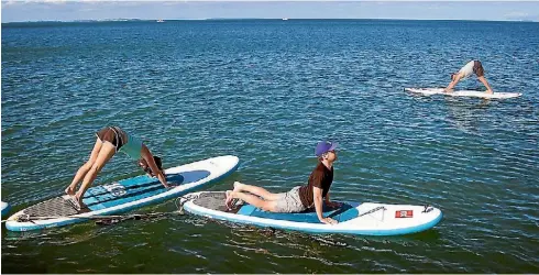  ?? CHRIS MCKEEN ?? Mastering various yoga positions on a stand-up paddle board adds a whole new element of balance.