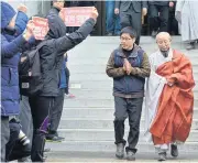  ?? AP ?? Korean Confederat­ion of Trade Unions President Han Sang-gyun, second right, walks to turn himself in to police at Jogye Temple in Seoul, South Korea, yesterday.