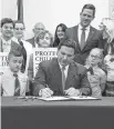  ?? DOUGLAS R. CLIFFORD Tampa Bay Times via AP In March, Florida Gov. Ron DeSantis signs the Parental Rights in Education bill at Classical Preparator­y school in Shady Hills. ??