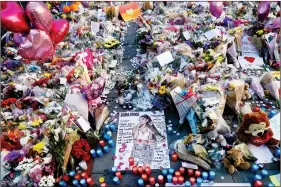  ??  ?? Flowers, messages and tokens are left in tribute to the victims of the Manchester attack, on Friday, in Manchester. REUTERS