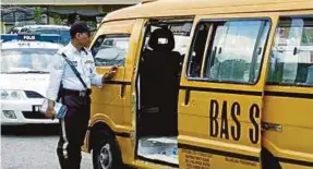  ??  ?? A traffic police officer checking a school bus in Tawau, Sabah, last year.