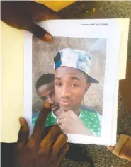  ?? AP PHOTO BY EMILY SCHMALL ?? Mamadou Aliou Barry, 17, who departed from his native Guinea in West Africa three years ago, shows a print of a selfie with a friend who drowned in Central America during their journey to the U.S.-Mexico border.