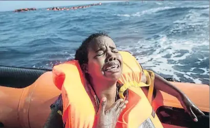  ?? CHRIS MCGRATH / GETTY ?? Una dona rescatada plora després de perdre el seu nadó al mar, en una llanxa de l’oenagé MOAS