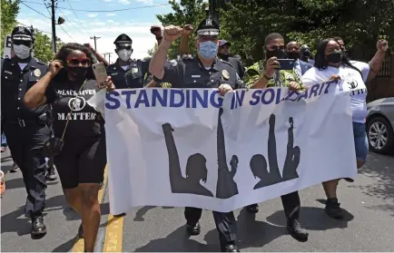  ?? April Saul via The Associated Press ?? Camden County Police Chief Joe Wysocki raises a fist while marching with residents and activists in Camden, N.J., on May 30 to protest the death of George Floyd in Minneapoli­s.