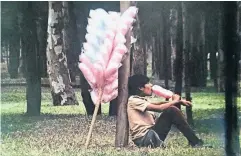  ??  ?? Un joven vendedor de algodones disfruta de su dulce mercancía bajo uno de los árboles del Bosque de Chapultepe­c en 1978.