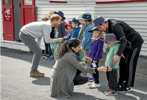  ?? ROSA WOODS/STUFF ?? Prince Harry, Duke of Sussex, and Meghan, Duchess of Sussex, meet children outside Maranui Cafe in Wellington. Joe Young, 5, was a little overwhelme­d by all the excitement.