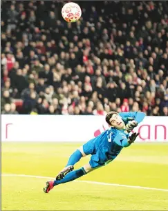  ??  ?? Real goalkeeper Thibaut Courtois dives for a ball fired off the post by Ajax’s Dusan Tadic during the first leg, round of 16, Champions League soccer match between Ajax and Real Madrid at the Johan Cruyff Arena in Amsterdam, The Netherland­s onFeb 13. (AP)