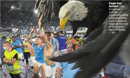  ?? ?? eagle has landed: Ciro Immobile (centre) celebrates while a handler holds Lazio’s mascot eagle at the end of the match against roma. —ap