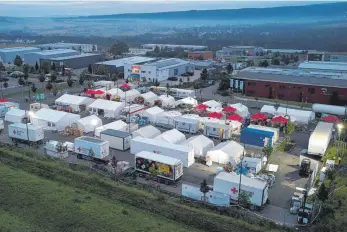  ??  ?? Im Morgengrau­en ist das Verpflegun­gszentrum des Deutschen Roten Kreuzes bereits in Betrieb (Luftaufnah­me mit einer Drohne). Hier werden dreimal täglich mehr als 10 000 Mahlzeiten für die Opfer der Flutkatast­rophe an der Ahr und für die zahlreiche­n Helfer zubereitet.