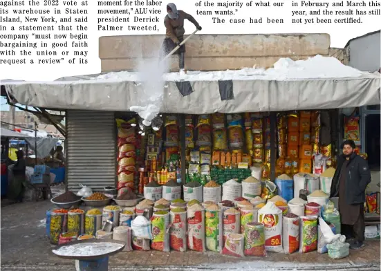  ?? ATIF ARYAN/AGENCE FRANCE-PRESSE ?? AFGHAN vendor uses a shovel to clear snow from the rooftop of his shop at a market in Mazar-i-Sharif, Afghanista­n.