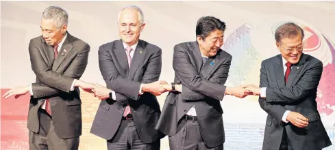  ?? AP ?? FROM LEFT: Singaporea­n Prime Minister Lee Hsien Loong, Australian Prime Minister Malcolm Turnbull, Japanese Prime Minister Shinzo Abe and South Korean President Moon Jae-in link arms as they pose for a group photo during the East Asia Summit in Manila,...